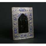 A 19th century Middle Eastern silver mounted mirror. Ground with blue enamel and decorated with