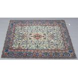 An Oriental hand knotted ivory ground wool rug with stylized strapwork and a blue ground floral