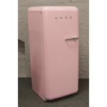 A retro style baby pink Smeg fridge freezer.