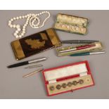 A box of collectables including two cased button sets, vintage pens, propelling pencils, post war