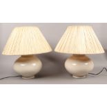 A pair of large ceramic cream coloured table lamps.