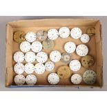 A box of pocket watch movements and enamel dials.