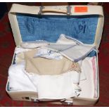 A vintage suitcase and contents of lace and linen.