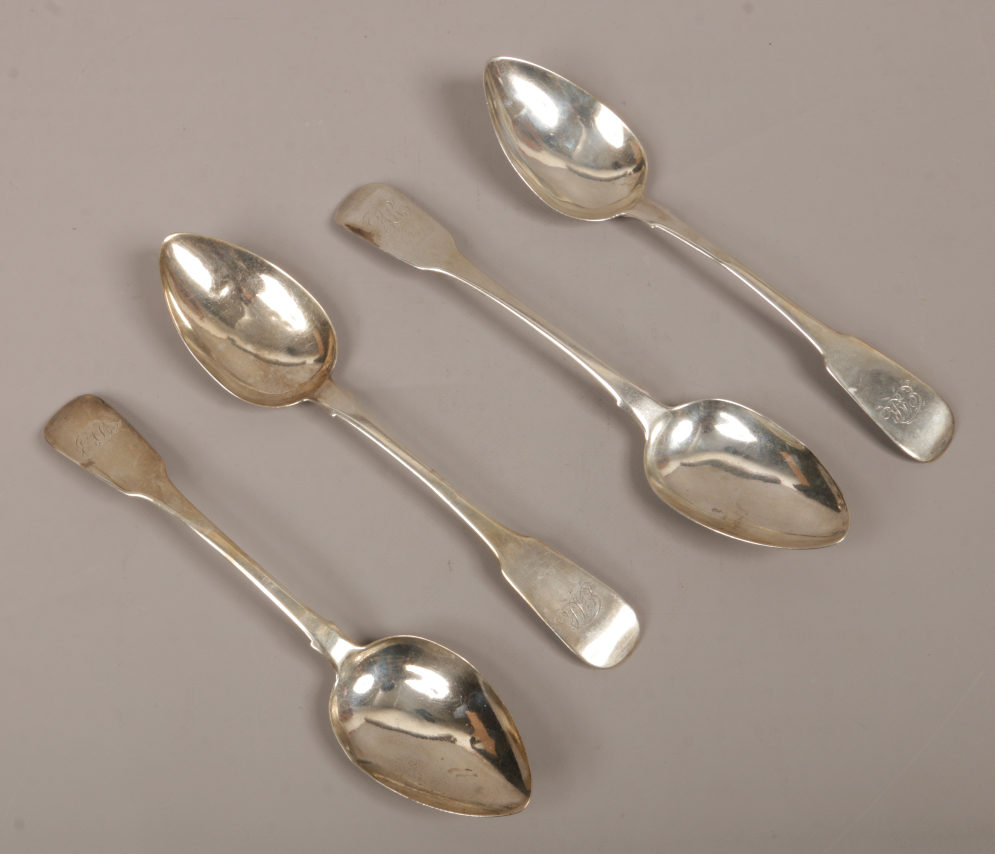 Four Georgian silver dessert spoons, three assayed Dublin 1821 by Joshua Buckton, the other London