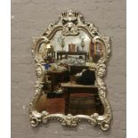 A large ornate silvered frame wall mirror, 116cm x 77cm.