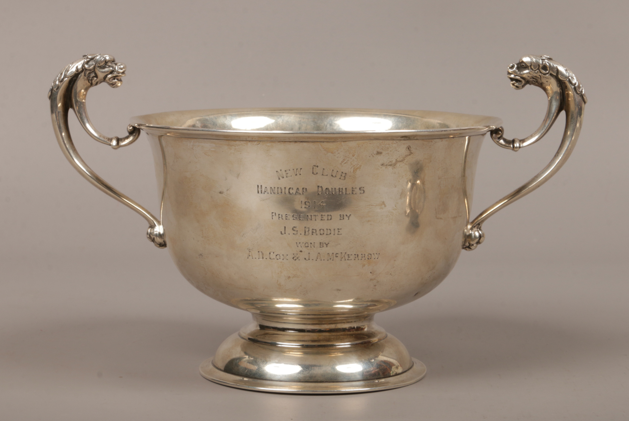 A George V silver presentation pedestal bowl with twin mask head handles, assayed Birmingham 1912 by