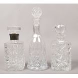 Three cut glass decanters with stoppers one with a white metal collar and one with etched