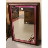 A wooden framed stained glass effect mirror.