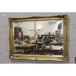 A large ornate gilt frame bevel edge wall mirror.