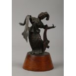 An Indian bronze figure of a woman dancing raised on a wooden plinth.