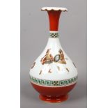A porcelain bottle vase. With red ground and key fret borders and decorated with a continuing band