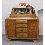 An Art Deco carved oak sideboard with domed mirror back.