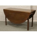 A mahogany drop leaf table on square legs.