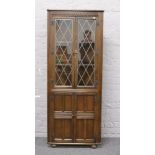 A carved oak lead glazed corner display cabinet.