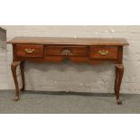 A carved mahogany three drawer side table raised on cabriole supports.
