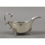 A heavy gauge sauceboat by John Rose with double scrolling handle and raised on cabriole feet,