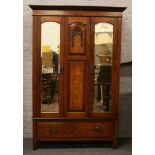 A carved mahogany mirror front double wardrobe over drawer base.