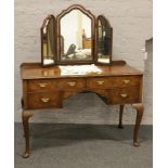 A Victorian walnut dressing table with triple mirror raised on carved cabriole pad foot legs.