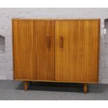 A large teak cupboard fitted with shelves and drawers, L 126cm H 109 cm x D 42cm.