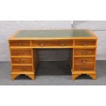 A yew wood twin pedestal desk with green leather inset top.