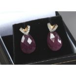 A pair of 9ct gold earrings set with diamonds and with faceted synthetic ruby droplets.