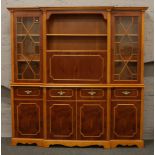 A large two tone yew wood display cabinet over drawer and cupboard base with brass metal mounts.