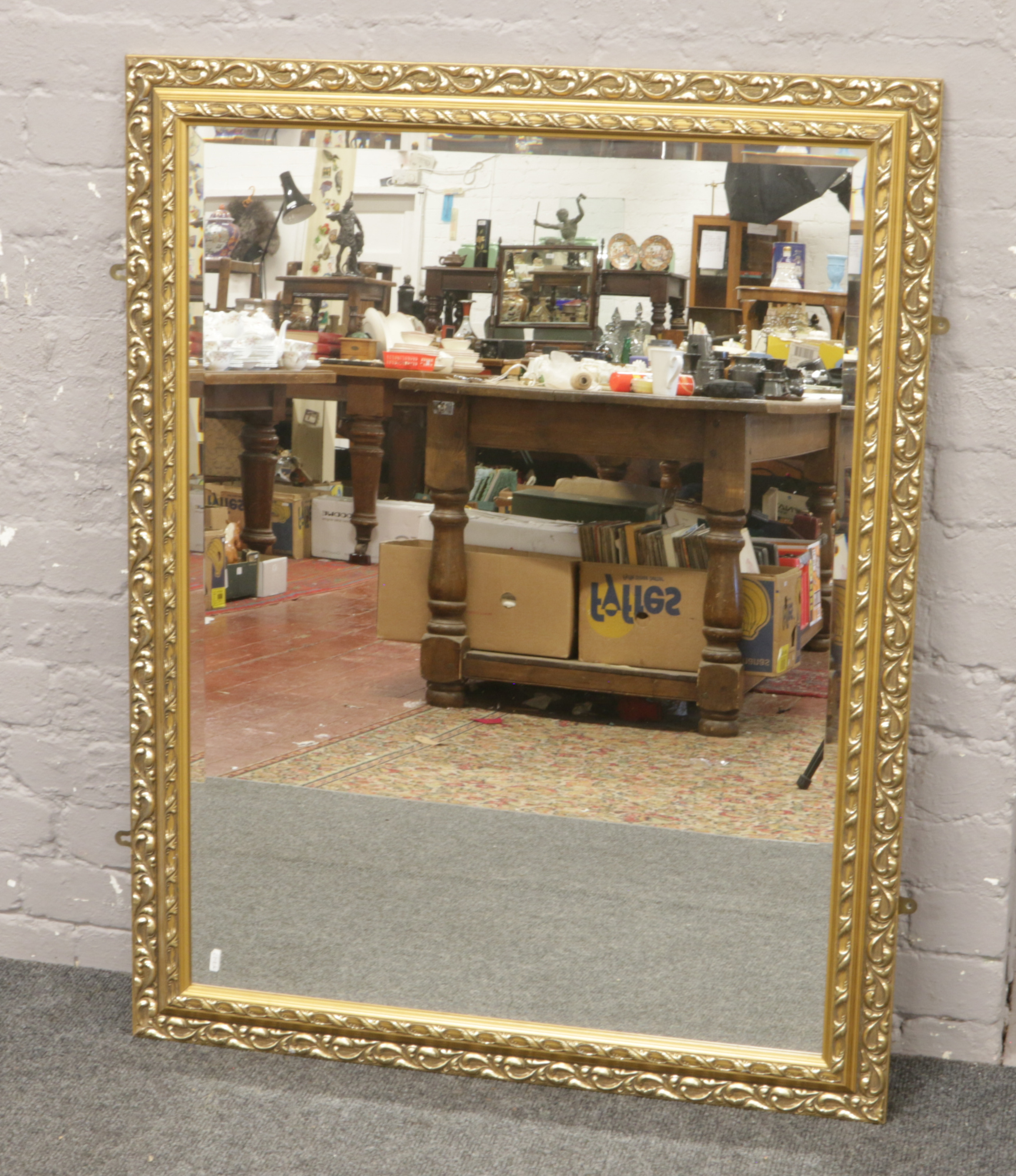 A large gilt framed bevel edge wall mirror, 90cm x 115cm.