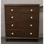 Victorian painted pine chest of four drawers, raised on squat bun feet and having later ceramic