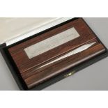 A cased presentation silver letter opener on rosewood stand presented to the RT. HON. REG Prentice