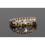 A gold and five stone diamond ring, set with old European cut stones in a boat shaped setting,
