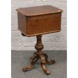 A Victorian rosewood centre pedestal teapoy. With fitted interior, turned centre pedestal and raised
