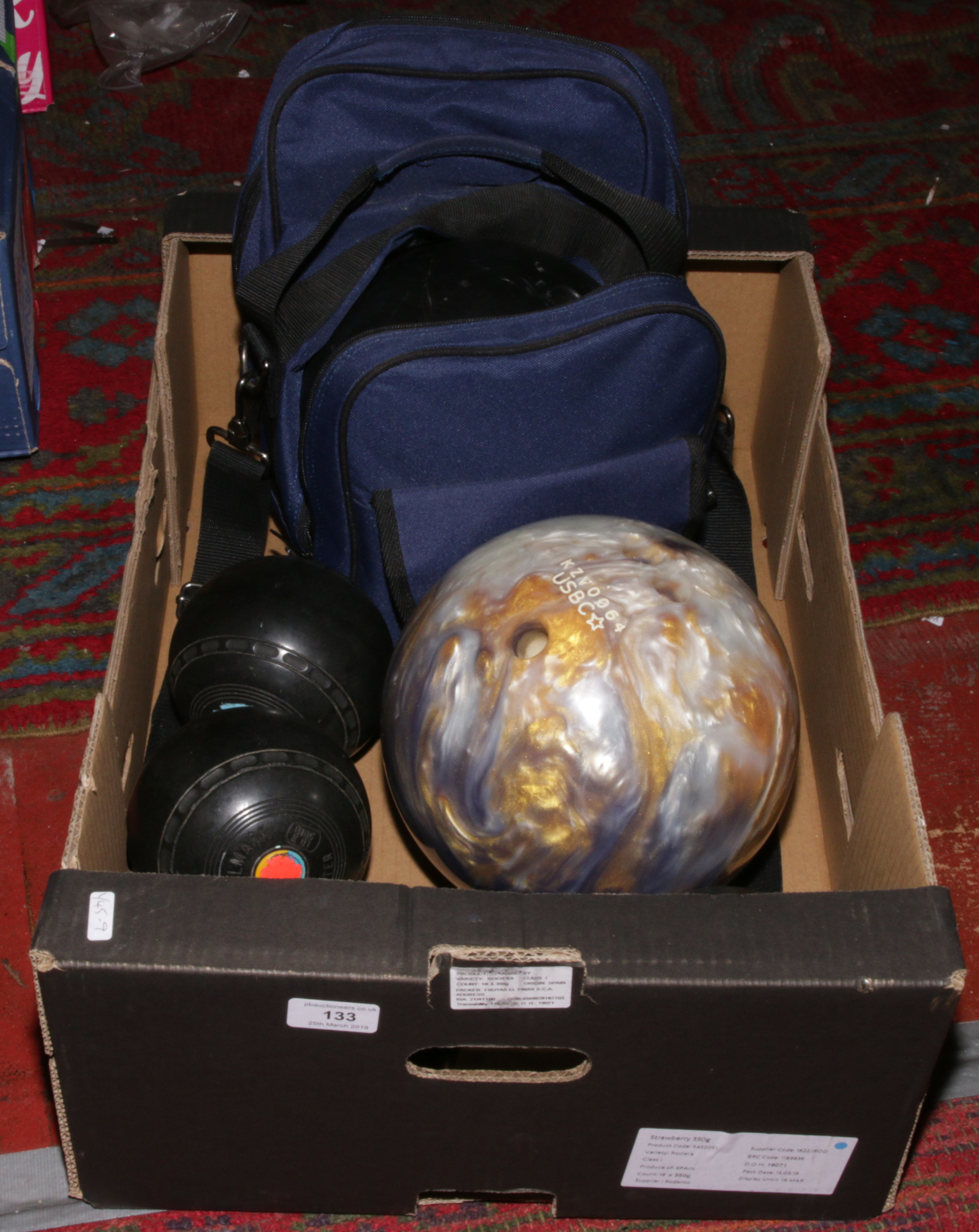 Two bowling balls one in case along with four lawn balls.