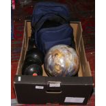 Two bowling balls one in case along with four lawn balls.