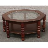 An octagonal mahogany and glass two tier occasional table raised on turned supports.