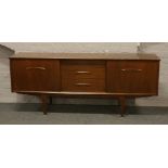 A retro mahogany sideboard with sliding doors and raised on in stepped tapering supports by Jentique