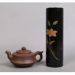 A Chinese Yixing red stoneware teapot and a cylindrical lacquer vase.