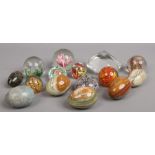 A tub of glass paperweights and carved and polished hardstone eggs.