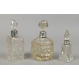 Three silver topped cut glass scent bottles with stoppers.