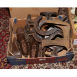 A box of metalwares including shoe lasts, large cast iron brackets etc.