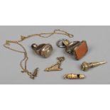 A quantity of yellow metal collectables including stone set seal fobs, miniature whistle, harp