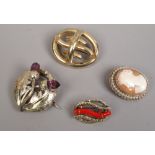 Four yellow metal brooches including a Scottish thistle and cameo examples.