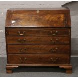 A George III mahogany bureau. With fitted interior having secret compartments and raised on