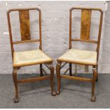 A pair of two walnut dining chairs raised on ball and claw cabriole legs.