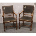 A pair of early 20th century mahogany library chairs both with Gothic style monogrammes to the