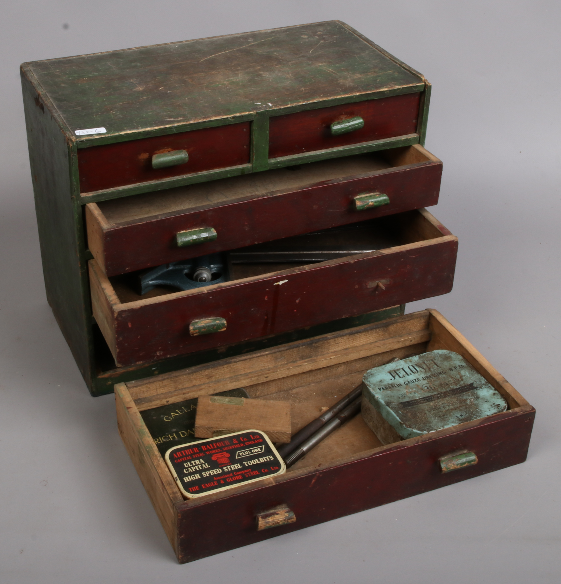 A painted miniature chest of five drawers and contents of engineering tools and vintage