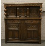 A carved and panelled oak court cupboard.
