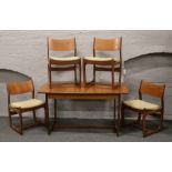 A teak extending dining table and set of four matching chairs.