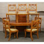 A yew wood oval twin pedestal dining table with extra leaf, raised on lion paw feet along with six