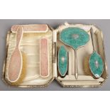 A pink shagreen three piece brush set, along with a similar green Art Deco example in case.