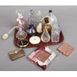 A tray of glass scent bottles, perfume atomisers and a powder compact.